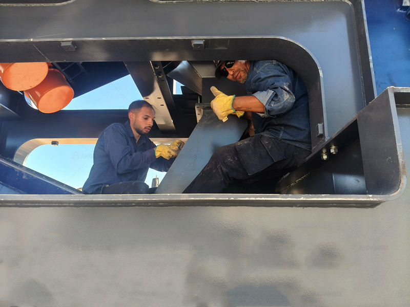Workers Maintaining Crusher Machine
